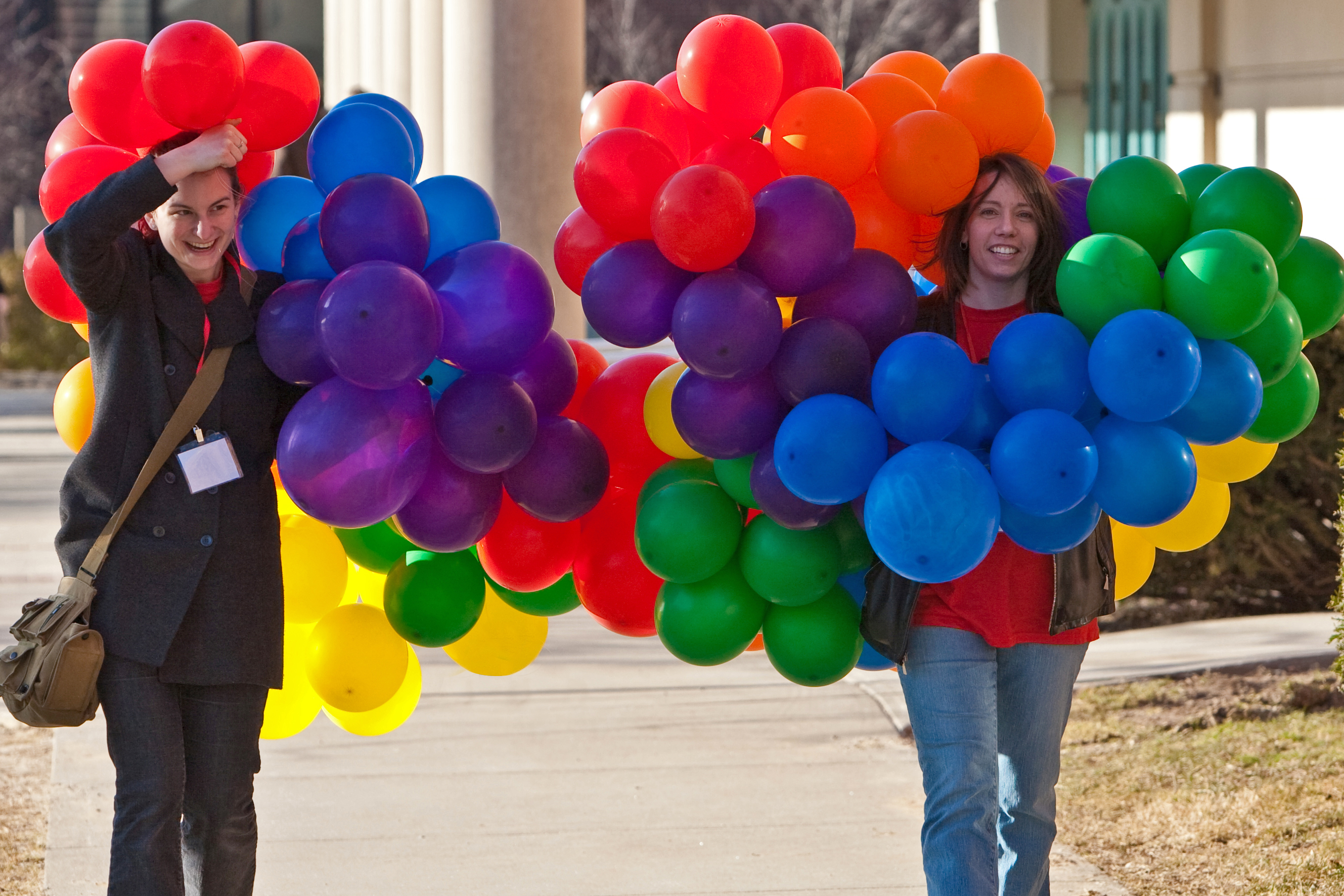 Two people walking with colorful balloons