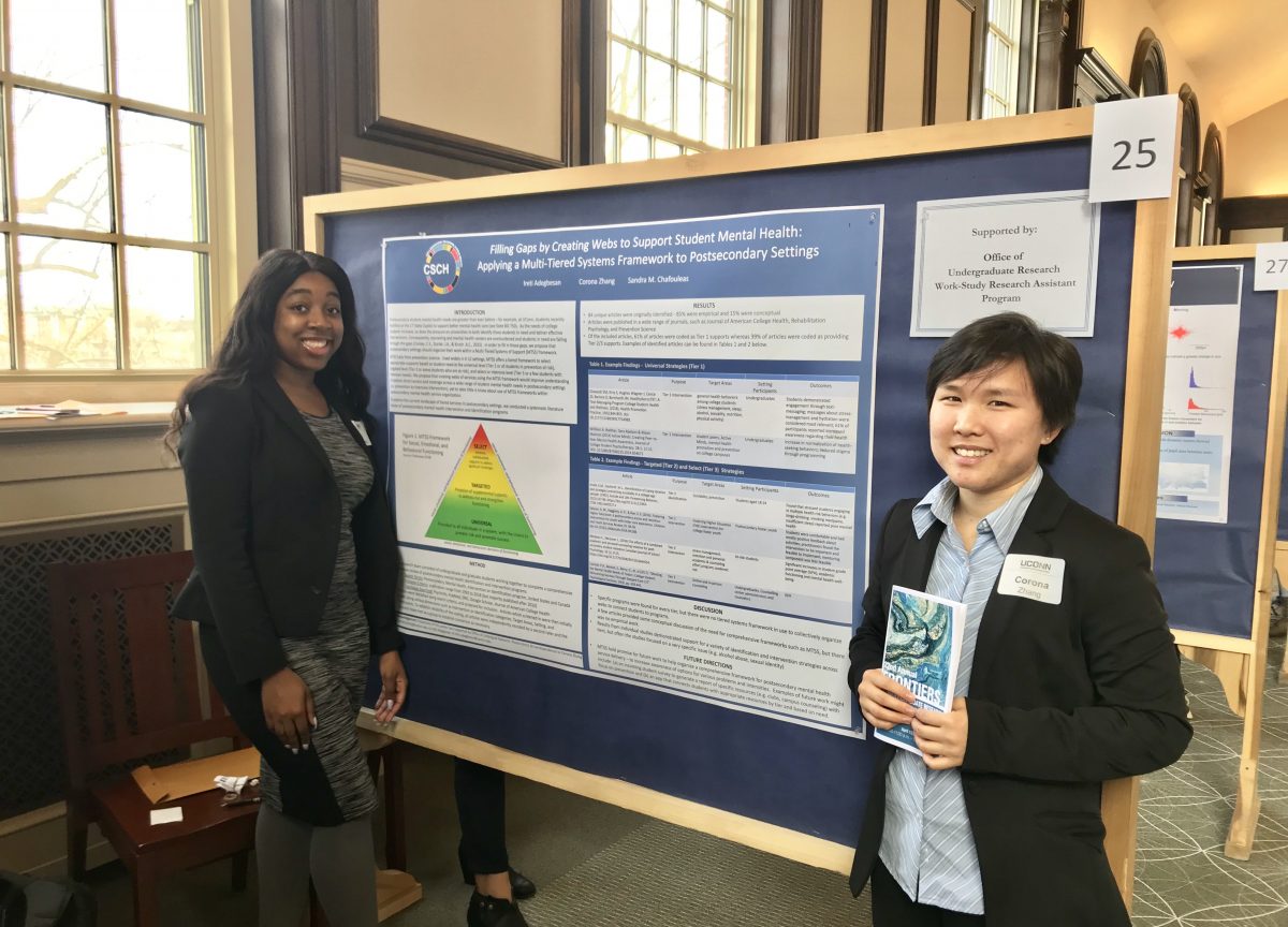 Ireti Adegbesan and Corona Zhang in front of poster presentation