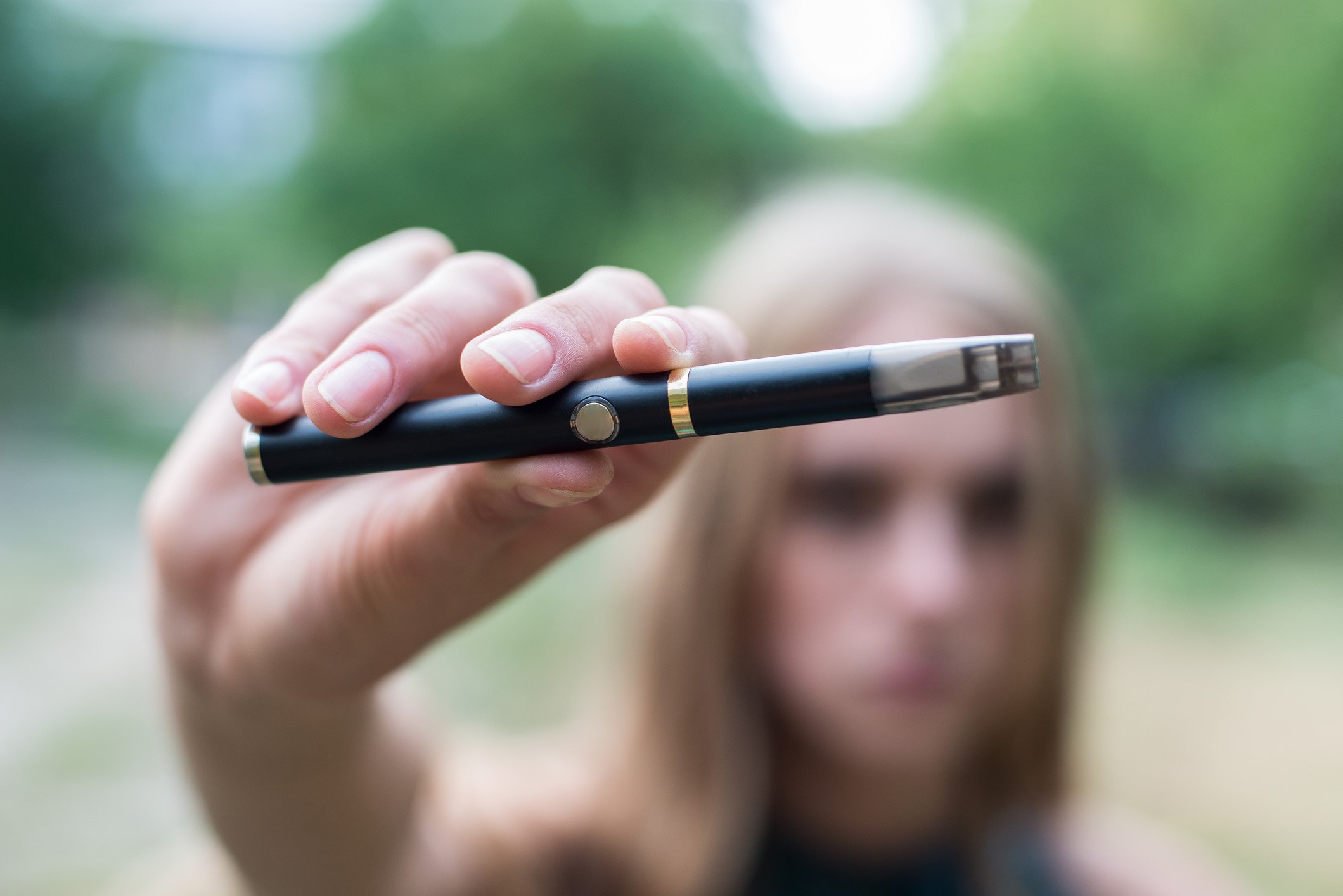 Girl holding electronic cigarette outdoor