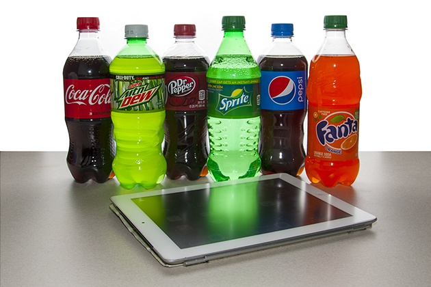Assorted soda bottles behind tablet