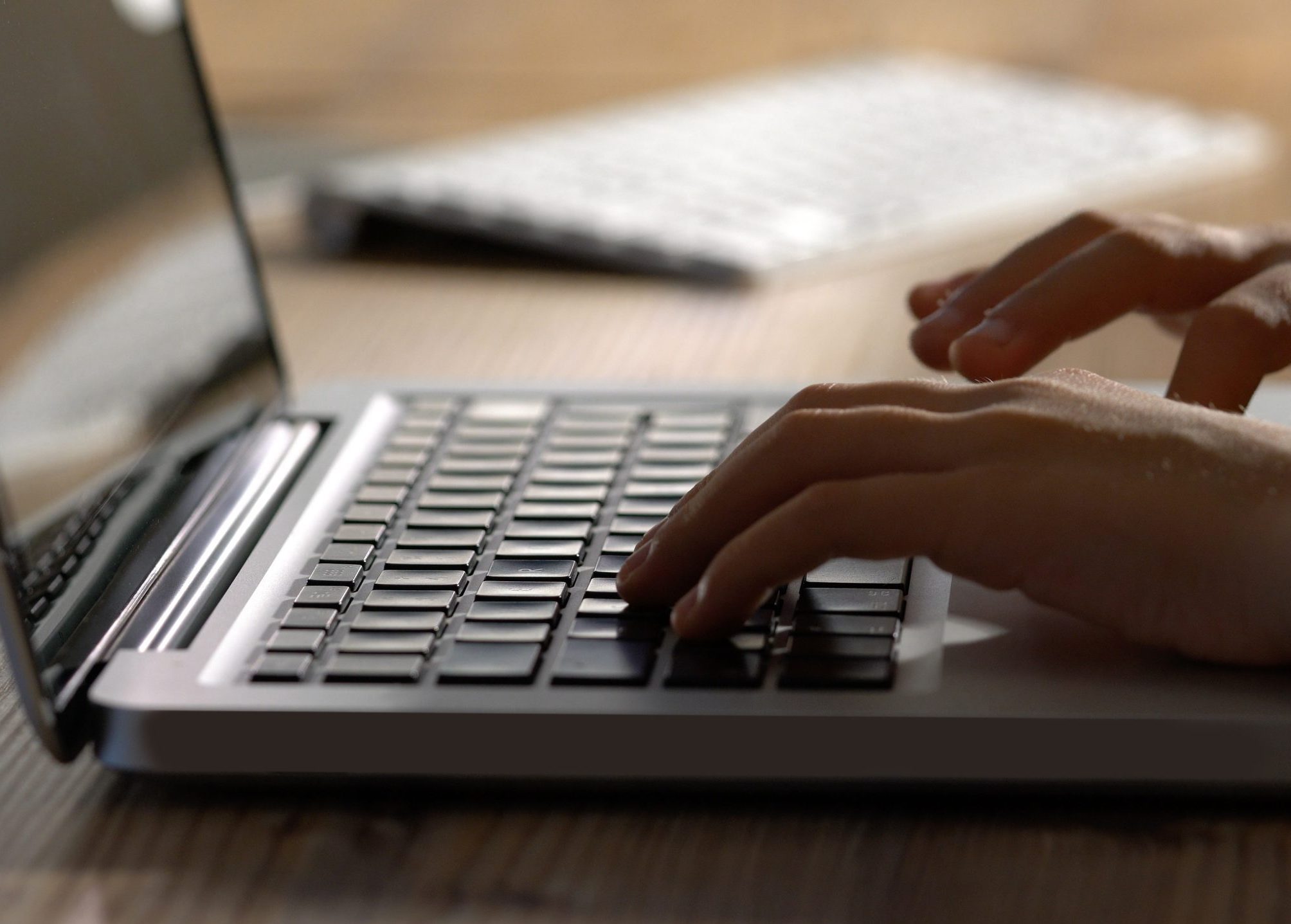 male hands typing on laptop keyboard