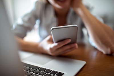 Close up of a young woman using her phone at home