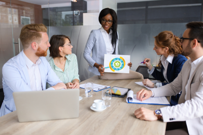 a team of adults meets around a table looking at the WSCC model