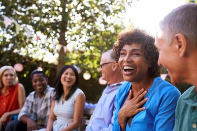 group of adults sits together outside smiling