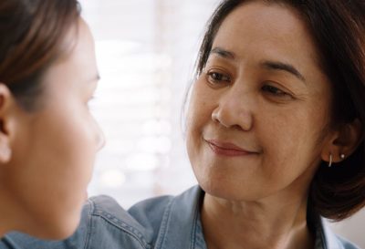 A woman faces a young girl with a small smile on her face