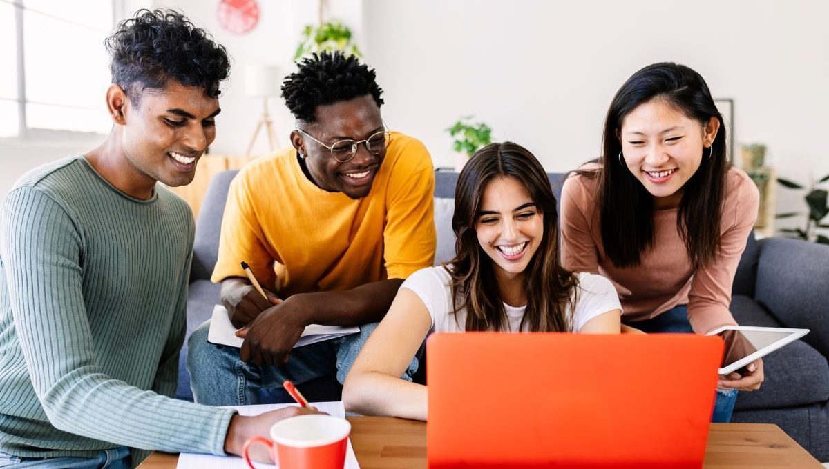 Young group of student friends studying together with computer at home 