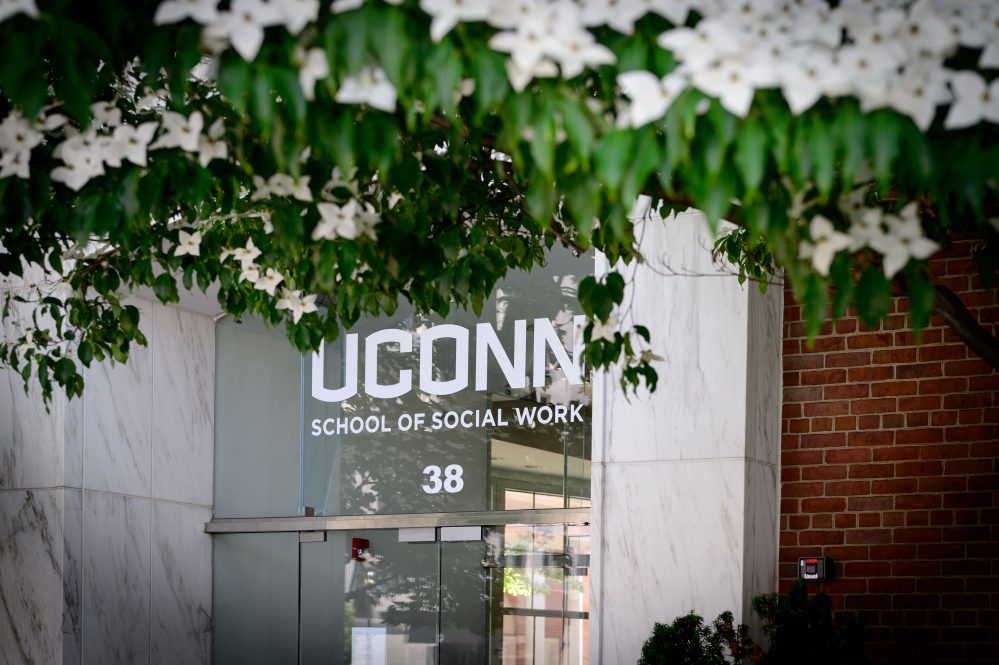 Glass door with UConn School of Social Work 38 written on it in white letters