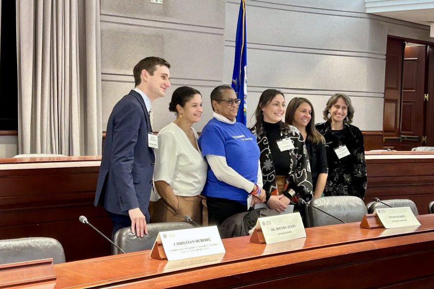 five panelists at Hartford Legislative office building stand and smile at camera